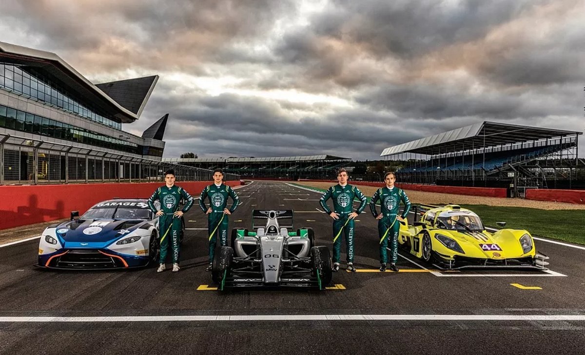 Picture of four young racing drivers and three cars on the start line at Silverstone